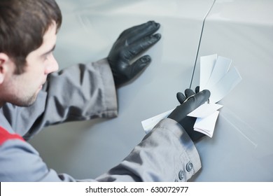 Colourist Man Selecting Color Of Car With Paint Matching Samples