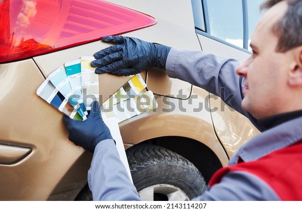 colourist man selecting color of car with paint\
matching samples