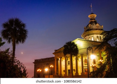 Columbia, SC—April 12, 2018; State House Illuminated At Dawn With Palmetto Trees And Crescent Moon In Background.