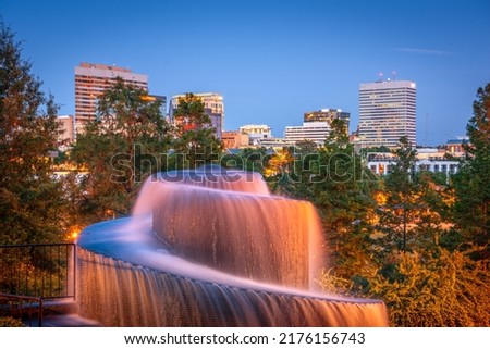 Columbia, South Carolina, USA downtown skyline and park at dusk.