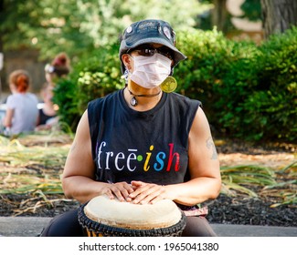 COLUMBUS, OH - APRIL 22, 2021: A Masked Woman Drums At A Protest For Racial Justice And LGBTQ Rights