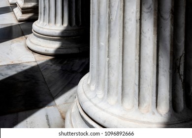 Column base on marble floor ground with dark shadows - concept architecture construction classical building structure stability strength culture history pillar detail close up