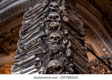 Column of human skulls with bones on the sides creating a macabre design of The Chapel of Bones located in the city of Évora in Portugal.17th century at the initiative of three Franciscan monks.