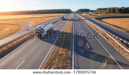 A column of modern tank trucks transporting liquid cargo along the highway. Concept of modern tankers with heated and cooled liquid cargo, background, semi-trailer