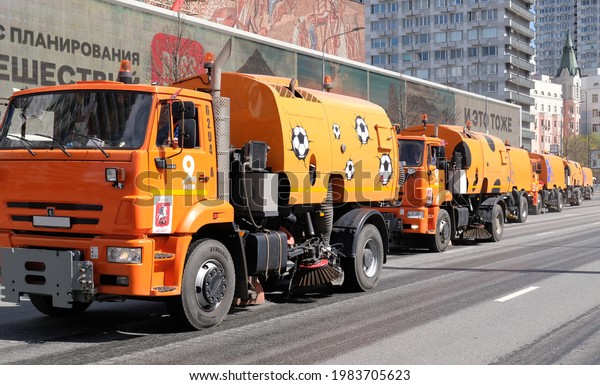 A column sweepers cars cleaning service in
Moscow - May, 2021. The sweeper is moving along the road. Сity
improvement by municipal services.
