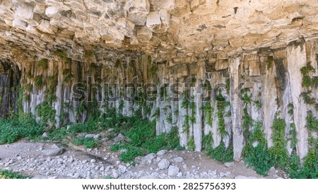 Columnar basalt rock formation under natural overhang