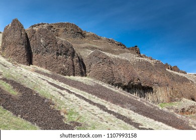 Columnar basalt rocks form a steep hillside with erosion creating falling gravel in Lyons Ferry State Park in Eastern Washington.