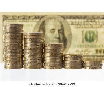 Columns of British Pound Sterling coins in decreasing heights on 100 american dollars bank note background, symbolising steep losses against the dollar.