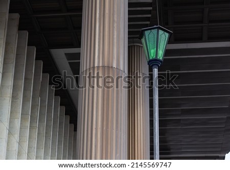 columns, ceiling sheathed with aluminium sheets and marble walls are illuminated by green lanterns. Detail of theater building pillars Art Nouveau. selective focus