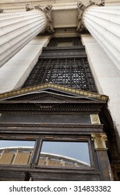 The columns and top of the doorway on one of the entrances to the US Post Office on 8th avenue in Midtown Manhattan. The reflection of Madison Square Garden can be seen in the glass panes
. 