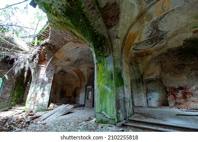 Columns of the vault of the hall of the old ruined abandoned Orthodox church in Russia. Broken floor and ceiling .Moss and peeling paint. Old red brick. Daylight.