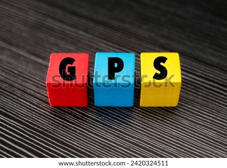 A colured wooden block with word “GPS” on it. GPS stands for “Global Positioning System”