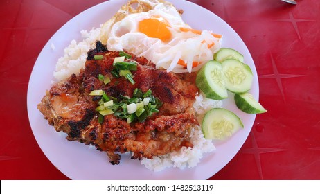 Com tam - Vietnamese broken rice with pickles steak grilled pork ribs cucumber onion oil sweet chilies garlic fish sauce fried egg omelet Asian cuisine