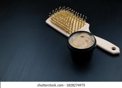 A Comb And Hair Dye In Black Container On A Dark Background