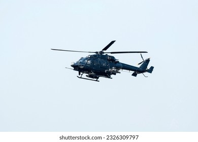 Combat Helicopter is going to attack enemy. Helicopter is flying on isolated blue sky.