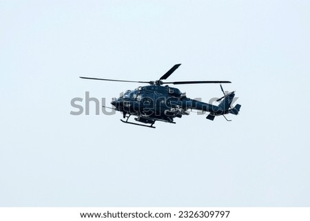 Combat Helicopter is going to attack enemy. Helicopter is flying on isolated blue sky.