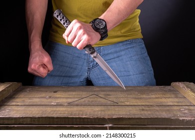 Combat knife grip. Knife fight. Stab. The man is holding a large narrow knife.