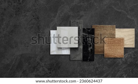 combination of interior material samples placed on dark black marble table including wooden ceramic floor tiles, luxury marble stones, elegance artificial stone tiles with blank space for design.