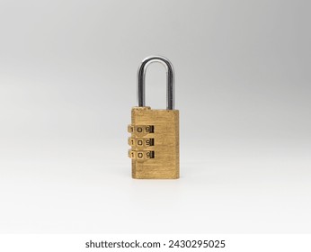 Combination lock on a white background. Closed bracket of the golden metal object. Safeguard measure to protect something.