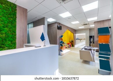 The combination of the modern office interior with the natural elements - wooden panels and the moss wall. The waiting area with advertising stands, and the play space for children  - Powered by Shutterstock