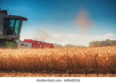 Combine harvester agriculture machine harvesting golden ripe wheat field - Shutterstock ID 645643516