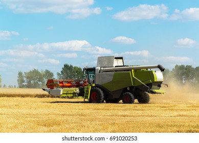 Combine harvester threshes wheat on the field, Russia - Shutterstock ID 691020253