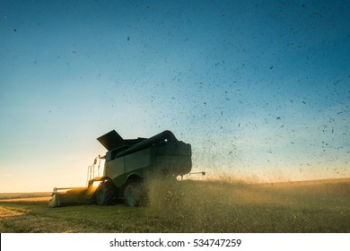 Combine harvester working on a wheat crop at sunset - Shutterstock ID 534747259