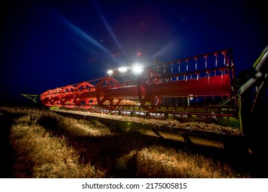 Combine Harvester Working In Wheat Field At Dark Night. Agriculture Background. Harvest Season