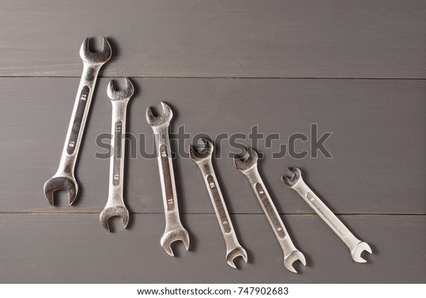 Combined keys to repair the car\
on the grey table in order of decreasing size. top view. flat\
lay