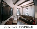 Combined kitchen and living room in a wooden Scandinavian country house. Cozy first floor of a modern wooden small house.