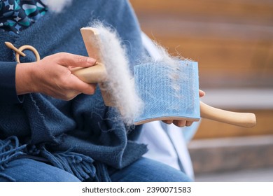 Combing animal hair with a brush for spinning woolen clothes - Powered by Shutterstock