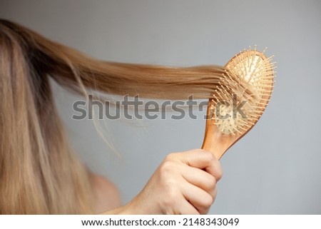 combing hair with a wooden comb
