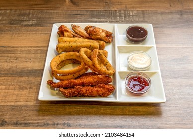 Combo Of Tex Mex Snacks With Chicken Strips, Onion Rings, Cheese Fingers And Fried Wings With Different Dipping Sauces