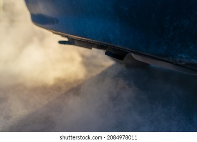 Combustion Fumes Coming Out Of Car Exhaust Pipe.Smoke Clouds Coming Out Of Automobile Tailpipe. Air And Environment Pollution By Vehicle Closeup Shot.Car Pipe Puffs Out Exhaust Gas Clouds.Closeup.