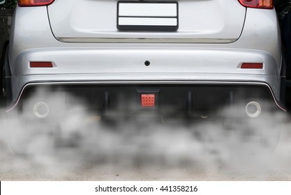 combustion fumes coming out of car exhaust pipe