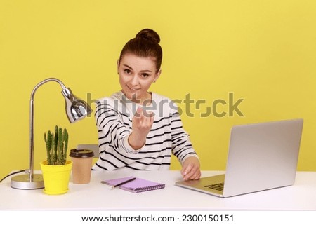 Come here. Woman manager sitting at workplace with laptop and making beckoning gesture, inviting to come hither, offering job application. Indoor studio studio shot isolated on yellow background. Stock photo © 