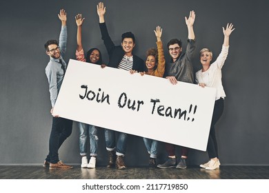 Come and join our team. Studio shot of a diverse group of people holding up a placard against a grey background. - Shutterstock ID 2117719850