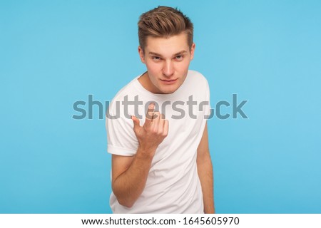 Come to me! Portrait of handsome man in casual white t-shirt making beckoning gesture and looking at camera with alluring eyes, flirting asking for date. indoor studio shot isolated on blue background Stock photo © 