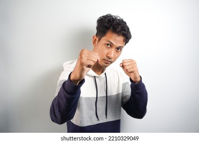 Come On Let Us Fight. Portrait Of Excited Self-assured Arrogant Male Model, Raising Fists And Standing In Boxer Pose, Wanting To Punch Someone While Drunk At Pub Over White Wall