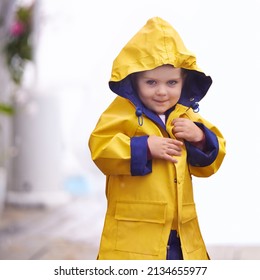 Come Play In The Rain. Shot Of A Young Boy Playing Outside In The Rain.