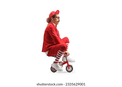 Comedian riding a small red bike isolated on white background
