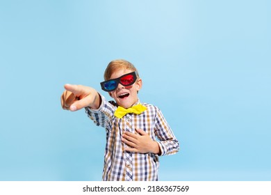 At Comedy Movie. Emotional Preschool Boy, Kid Wearing Retro Style Outfit And 3d Glasses Isolated On Light Blue Background. Concept Of Child Emotions, Facial Expression, Fashion And Ad.