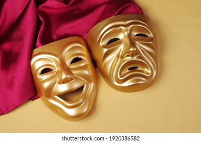 Comedy and tragedy masks with purple drapery on a yellow background. Theater symbol.