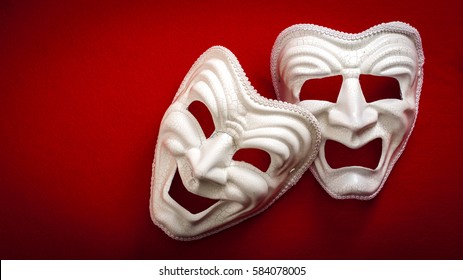 Comedy and Tragedy theatrical mask isolated on a red background and copy space
