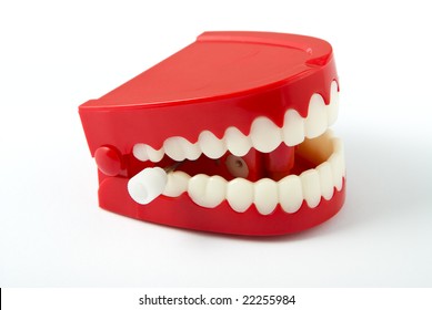 Comedy wind-up chattering teeth isolated on white with clipping path. Facing to front right and showing winder.