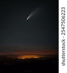 A comet lights up the night sky shortly after sunset over an illuminated city in Lugo Galicia