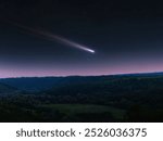 Comet tail in the sky, night landscape. Comet surrounded by stars over hills. Astrophotography of a celestial body.