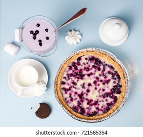 Comfort Food. Blueberry Open Pie Served With Milk, Smoothie, Marshmellows And Cookie On Pale Blue Table Above View