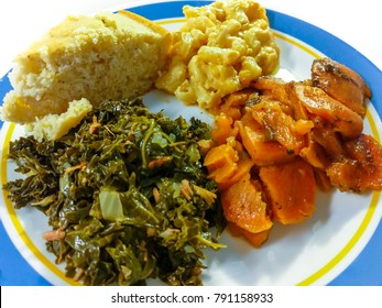 Comfort Food. A Serving Of Kale Greens With Smoked Turkey, Candied Yams, Macaroni And Cheese, Cornbread On A White And Blue Plate. Southern Cuisine.