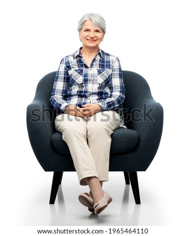 Similar – Woman sitting in a chair and reading books